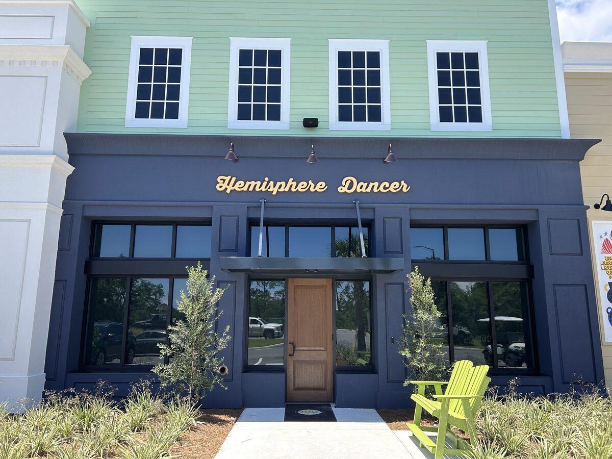 Hemisphere Dancer script signage on dark navy storefront — Latitude Margaritaville Watersound, FL — by CG Signs