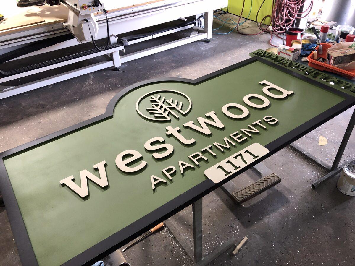 Carved HDU sign with raised letters, textured background, painted finish, and reflective vinyl accents — CG Signs