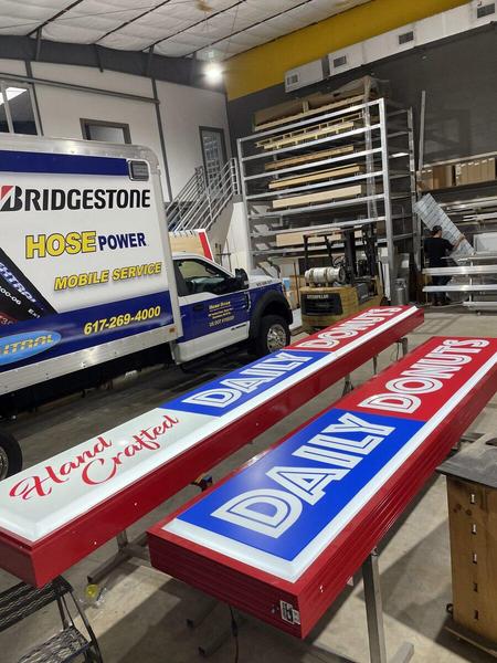 Illuminated cabinet signs and box truck wrap inside our shop — Custom Graphics & Sign Designs, Jacksonville FL