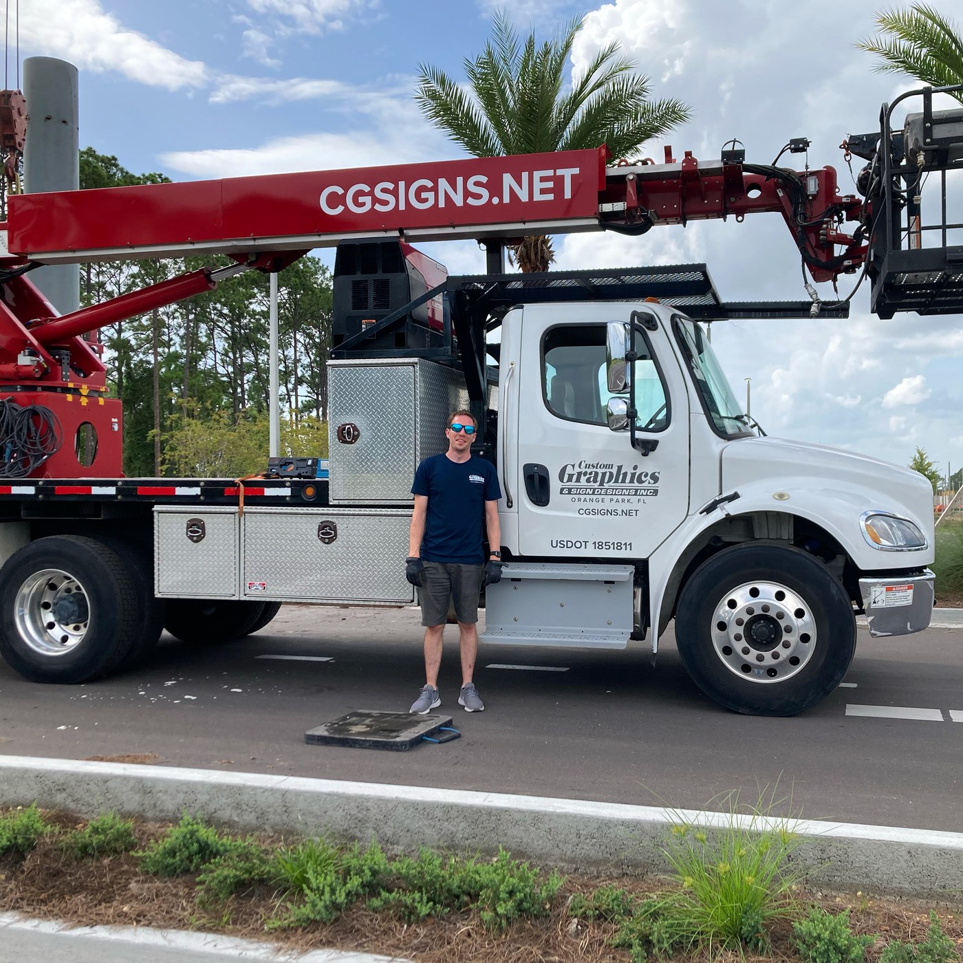 Jamie Thole standing in front of the CG Signs Elliot L60 boom truck — Orange Park FL sign company installation crew